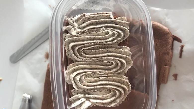 奥利奥咸奶油蛋糕盒子,底下先铺上一张蛋糕,挤上一层奥利奥奶油撒上一层奥利奥碎。依次类推。