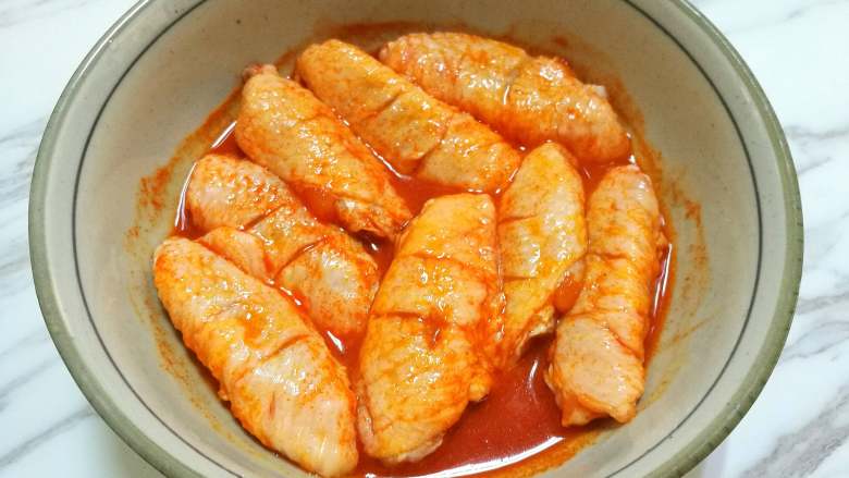 新奥尔良烤鸡翅,倒入装鸡翅的大碗里，拌均匀后腌制4小时以上。
