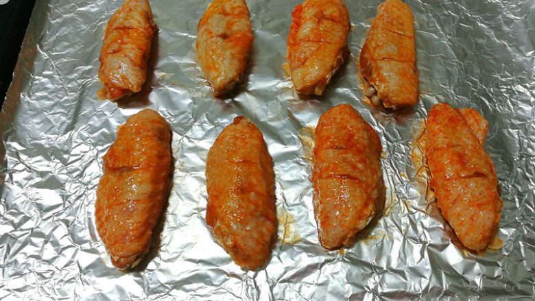 新奥尔良烤鸡翅,烤盘铺锡纸，将腌好的鸡翅放入，表面刷上腌制的料汁。