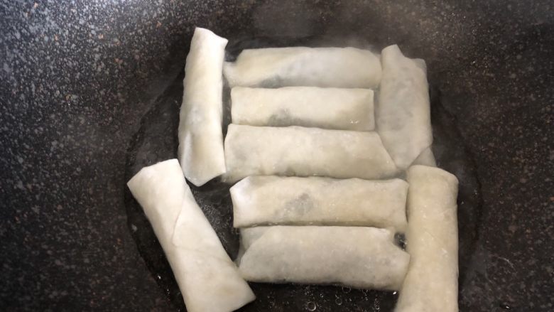 荠菜春卷,热锅倒入少许植物油,把春卷放进去。!