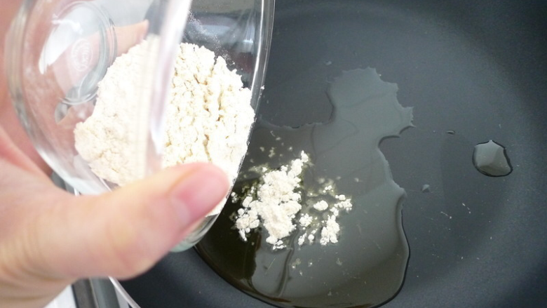 芝麻千层油酥火烧,待油稍微热之后,倒入面粉。