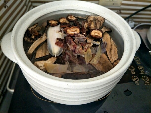 草根猪蹄汤,把焯过水的猪蹄放入砂锅,加入适量清水,放入草根、干香菇和目鱼干