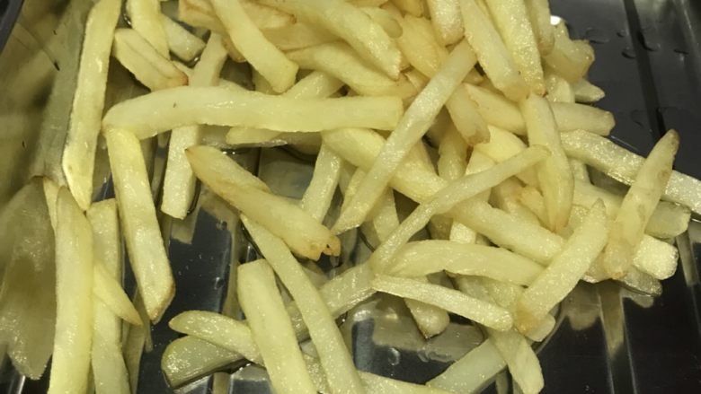炸薯条,金黄捞出,等待复炸。