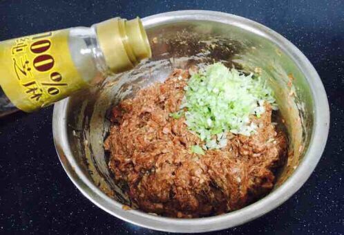 大年初五 破五 迎财神 吃饺子 芹菜猪肉水饺,最后放入葱花,在葱花上放约10g左右的香油,先用香油把葱花拌匀,再将葱花与肉馅充分调匀,即朝一个方向搅拌均匀,大约搅拌100下左右。 先用油裹住葱花的目的是防止葱汁外溢,造成肉馅葱味过重。猪肉馅调好了备用。