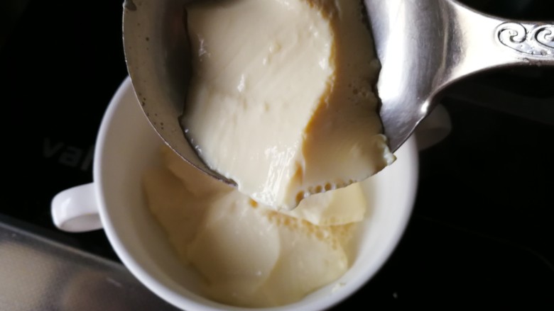 自制美味豆腐脑,凝固好豆腐脑盛入碗中,倒入冲好的盐、生抽调好的汤汁,放上咸菜、香菜、<a style='color:red;display:inline-block;' href='/shicai/ 852'>辣椒油</a>。