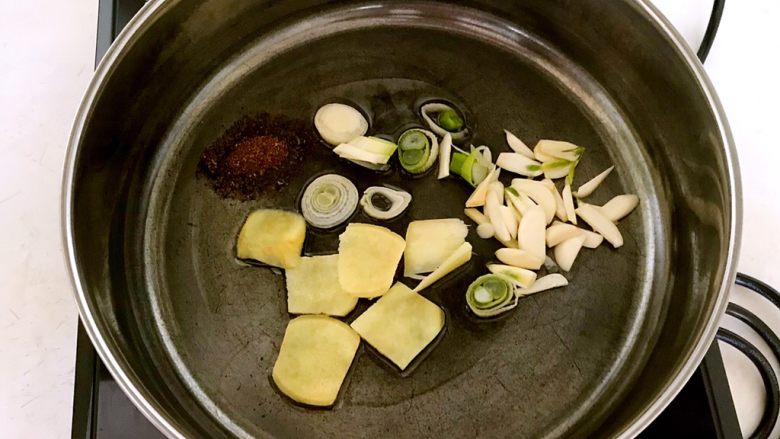 豆扣烧排骨,锅里烧热后加入1勺大豆色拉油,油烧热后放入<a style='color:red;display:inline-block;' href='/shicai/ 12043'>花椒粉</a>,姜片,葱花和蒜片,煸炒出香味