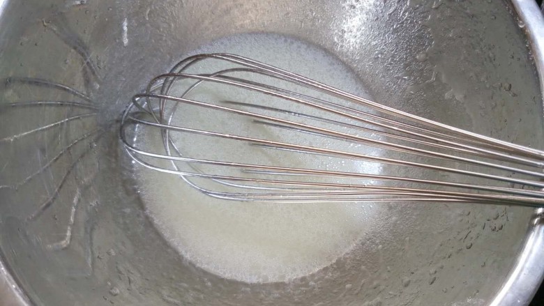 蔓越莓纸杯蛋糕(后蛋法),盆里加入水和油,用蛋抽搅打至乳化,基本看不到有油花,液体会呈现出稍稠的酸酸奶状。