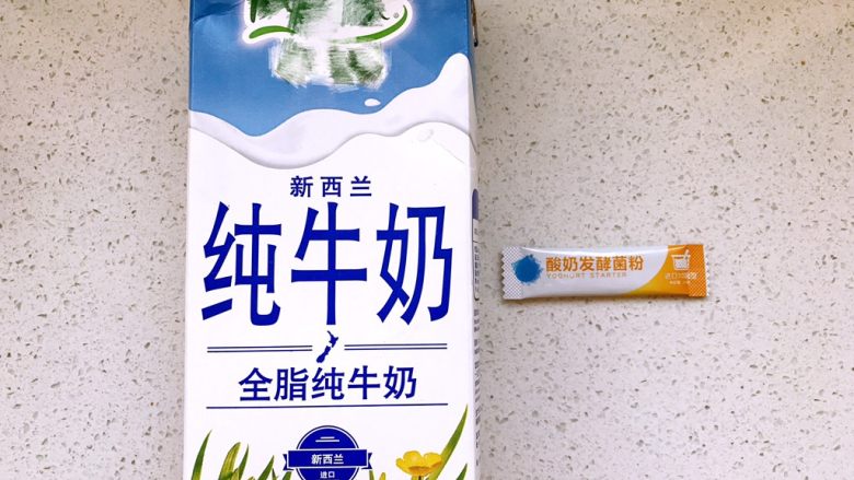 自制黄桃酸奶,准备1升装的常温全脂纯牛奶和1小袋常温酸奶发酵菌粉,把菌粉倒进牛奶里摇匀;