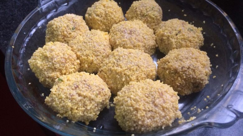 小米冬笋肉丸,小米沥干水,手抓肉丸捏成球形,裹一层小米,放入蒸锅。