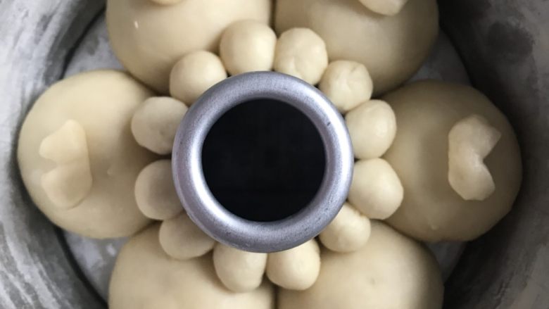 旺旺挤挤包,再从剩余的面团里切12个2克的小面团,揉圆,依次挨着烟囱排放,充当小狗的耳朵