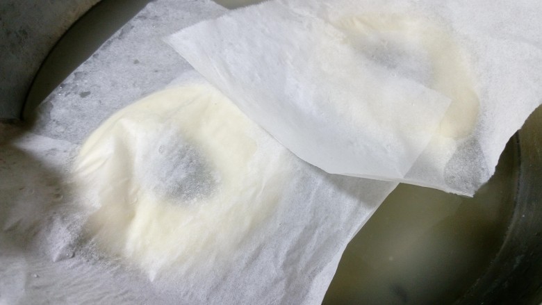 原味贝果(超详细版),将发酵好的面团取出,用手托着连油纸一起放进糖水,油纸自然会掉落。(因为贝果底部可能会粘,如果直操拽下来,会导致变形,而且面团易塌掉,这也就是一定要放在油纸上的原因。)