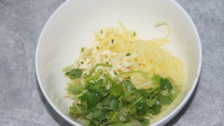 炝拌土豆丝,把土豆丝,香菜末和蒜末放进一个碗里