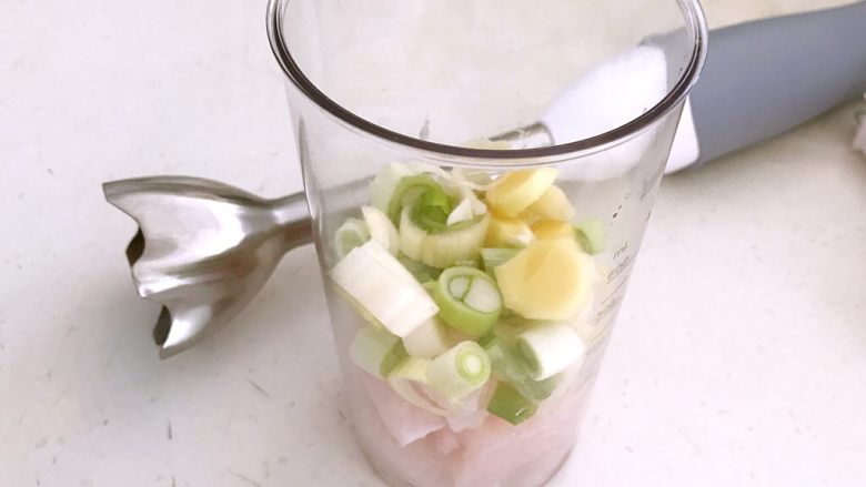 砂锅鱼丸紫菜汤,把葱花和姜片,龙利鱼块放入料理杯中