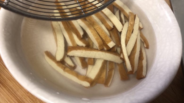 凉拌豆干香菜,豆腐干捞出来放在冷开水里浸泡一下,冷却后捞出来。