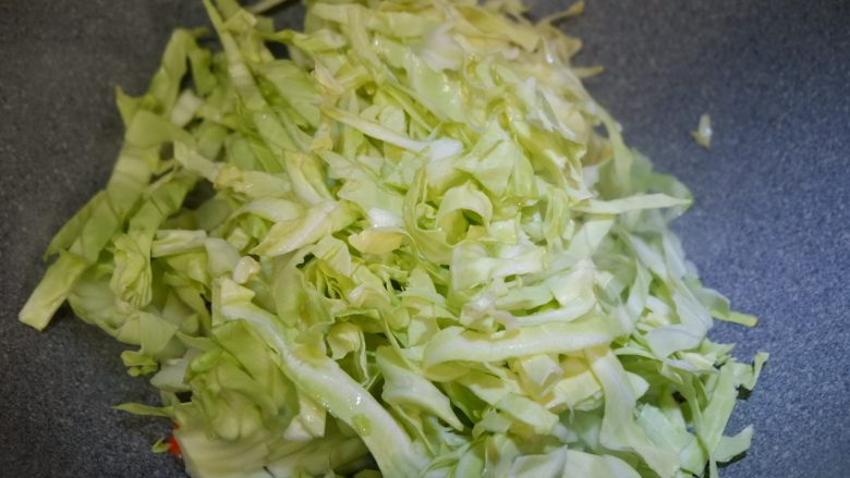 圆白菜炒粉丝,加入圆白菜,翻炒片刻。