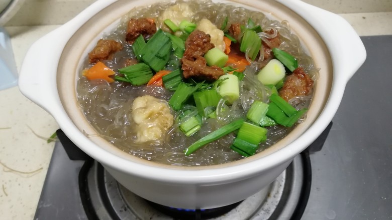 肉丸红薯粉丝煲,加入大葱,盖盖煮一会