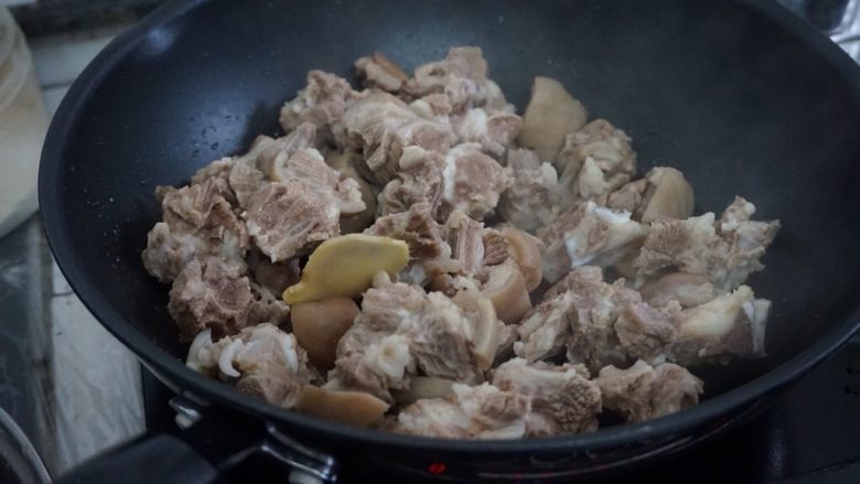脆肉鲩焖羊肉,热锅下油,加入姜片,倒入羊肉煸炒