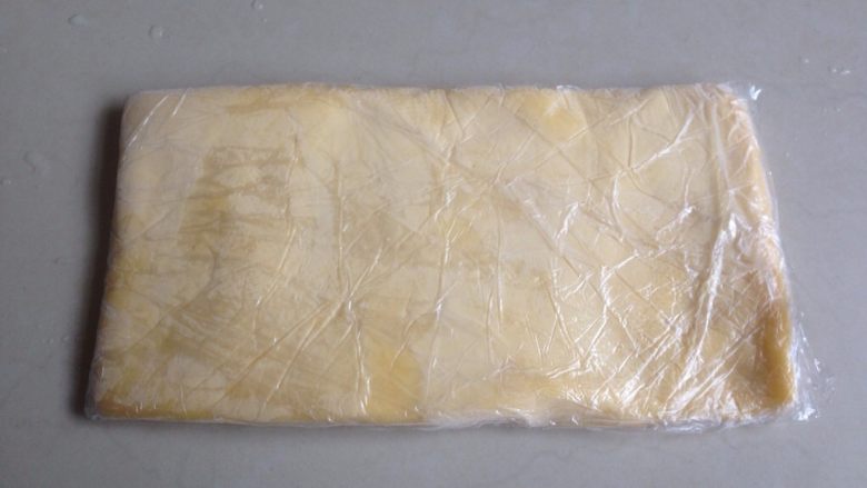黄油饼干棒,将黄油面团用保鲜膜包裹,用擀面棍压成长方形的0.5CM左右厚的薄面片,放进冰箱冷冻层冷冻至硬