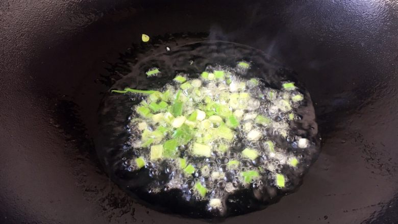 天津特色小吃 蔬菜烩饼,热锅凉油放入小香葱葱花,将葱花煸出香味。