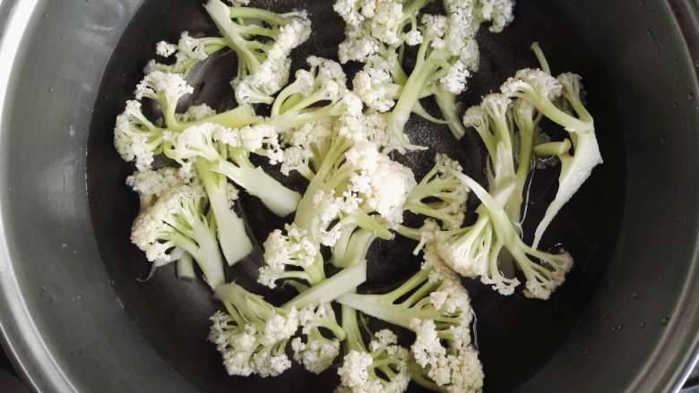 干香味美的清炒花菜,锅中烧开水,将花菜倒入锅中,焯水,焯至八成熟即可。