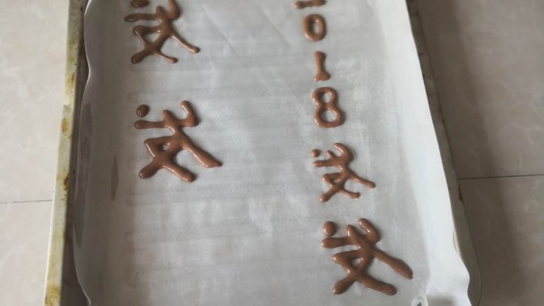 “发财”蛋糕卷~2018专属,油纸上提前薄薄涮点油,然后把可可液裱出字体,送入烤箱预烤5分钟定型取出,再倒蛋糊(字体要反面写,这样卷起来才能显示正面,否则按正常写字,反面卷起字就反了)