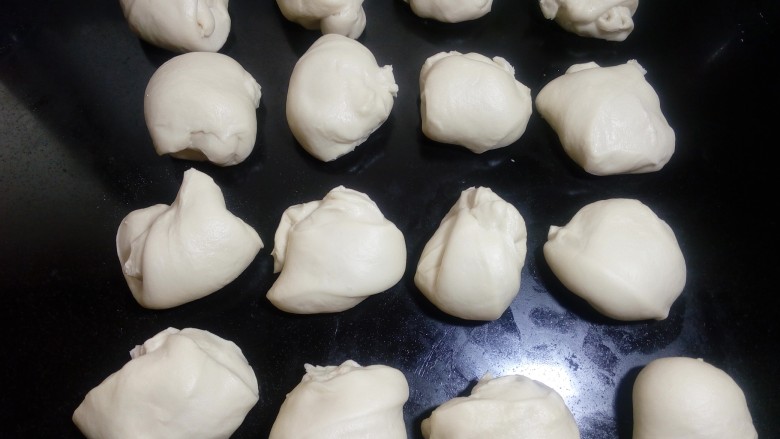 凤梨馅酸奶餐包(一次发酵),平均分割成16份,分割时尽量以面团的光滑一面,把切碎的部分包裹在里面。