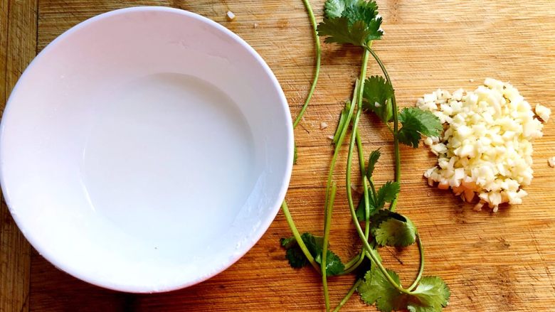 蒜香排骨,这时候我们把蒜去皮切末,香菜洗净,把剩下的10g玉米淀粉加入一点水兑成芡汁
