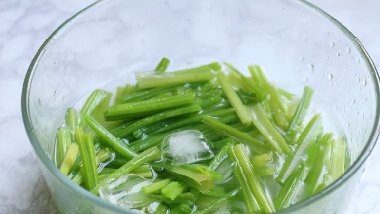 腰果仁炝芹菜,芹菜捞出放入冰水中浸泡,完全冷却后捞出沥水。