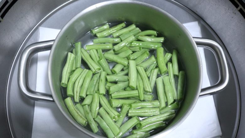 干煸四季豆,四季豆下锅煮七成熟，大约两分钟。