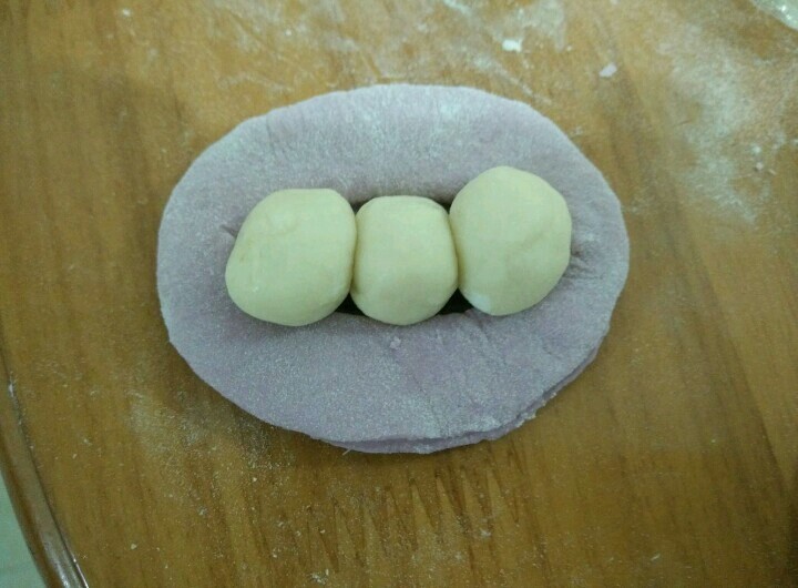 豌豆荚馒头,每个白色小圆抹点油,摆在紫色面团中间。