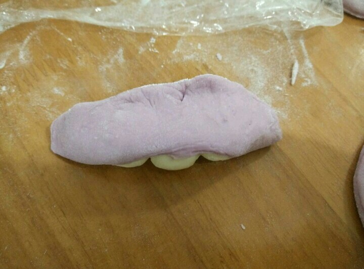 豌豆荚馒头,然后把紫色面团包起来,捏紧。