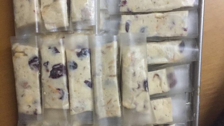 坚果蔓越莓牛轧糖,取出牛轧糖切条,包上食用糯米纸