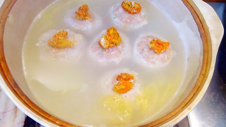年味~蟹粉狮子头,将蟹黄分别置于每只肉圆顶部,然后上盖白菜叶,是为了防止炖的过程中,蟹黄不会因为水汽滑落,肉圆顶部不干裂。烧沸后开微火焖2小时,上桌时揭去菜叶。