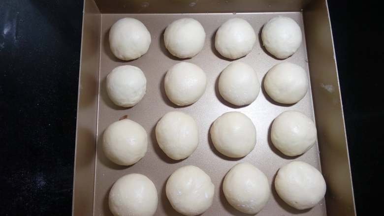 挤挤熊小面包,然后再次排气滚圆排在模具中,我使用的模具是26x26x5的三能深盘。进行二次发酵,现在天气也比较热了,把模具置于密闭空间或盖上保鲜膜室温发酵即可,也可以放发酵箱以35°二发。
