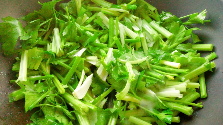 节后减脂菜~芹菜炒豆干,锅中油热后放芹菜翻炒。
