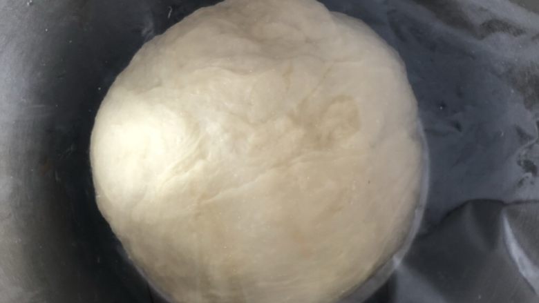 杏仁奶油排包,揉成光滑的面团后滚圆,盖上保鲜膜放在温暖处发酵
