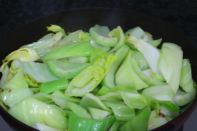 包心芥菜咸鸡煲,炒至芥菜微软,色泽油亮碧绿,调入盐、倒入两碗开水拌匀