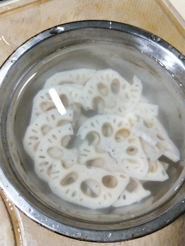荷塘小炒,把莲藕放入凉水中浸泡,倒入些许白醋防止变黑。泡10分钟后,将莲藕焯水,投凉。