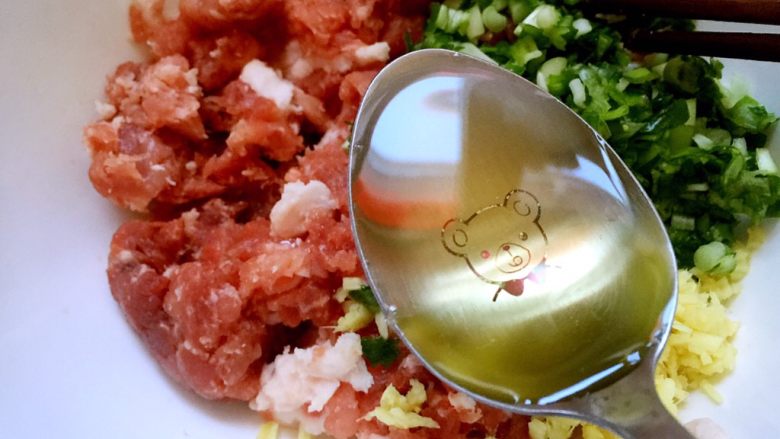 初五吃饺子-猪肉芹菜水饺,猪肉和大葱生姜一起放入碗中,放入玉米油