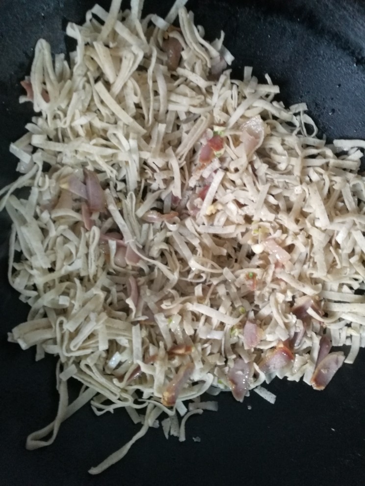 炒豆丝,倒入豆皮翻炒十分钟，中间放少量水闷一下豆丝比较软