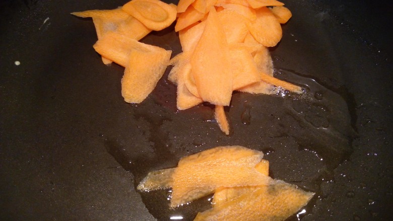 三色拌黄瓜, 锅里倒少许油，放入胡萝卜片。