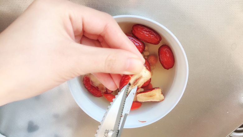 助攻熬夜疲乏—养肝豆浆,用厨剪把红枣核剪去。