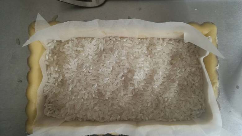 杏仁缤纷水果挞,垫上油纸,用塔石压住(塔石可以用豆类或者大米代替),烤箱160度,中层上下火,25分钟左右,观察上色情况,边缘略上色时将塔石取出,塔底放回去继续烤(温度和时间仅供参考)