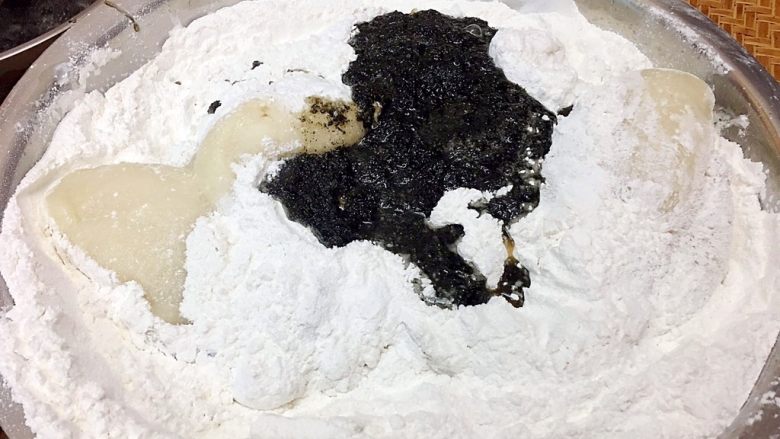 田艾印粿,取7包糯米粉倒入盆中,加入蒸好的糯米面团和田艾芝麻浆!