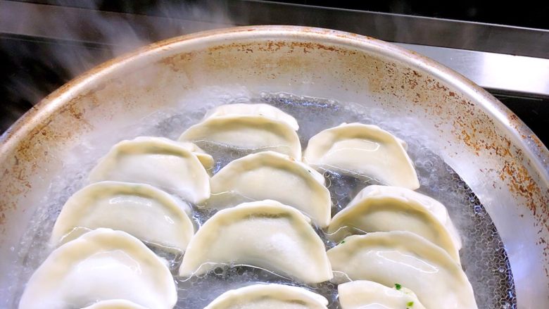 荠菜猪肉煎饺,煎30秒后加入热水，大学到饺子2/5的位置即可，大火并盖上锅盖。