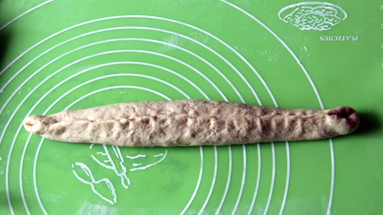 粗粮长棍面包,口子收紧,再滚成光滑的圆柱。