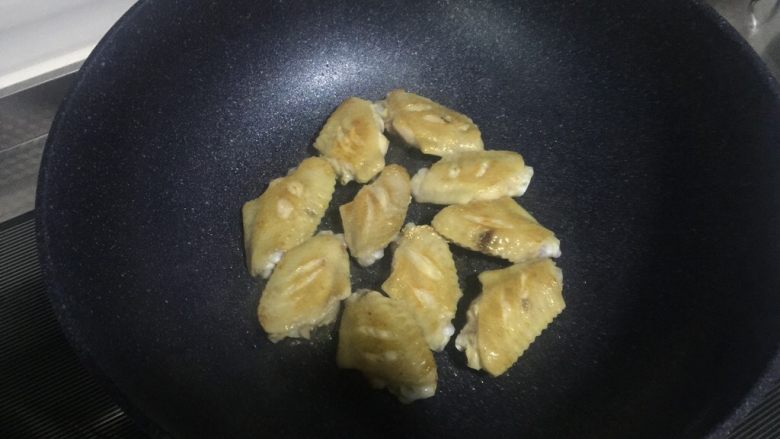 辣感可乐鸡翅~,煎至表面金黄出油,翻面,煎至另一面金黄出油捞出备用。