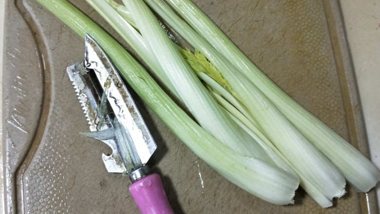 腰果木耳炒西芹,用削皮刀去除西芹背面的老筋。