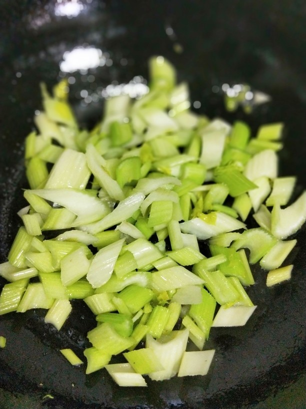 腰果木耳炒西芹,锅里放油,待油热倒入西芹粒煸炒。