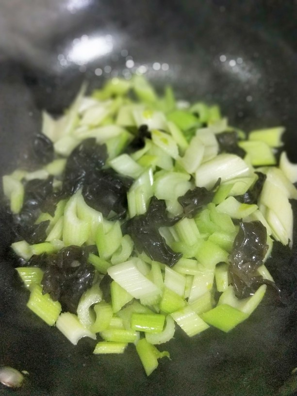 腰果木耳炒西芹,待西芹炒一分钟后,加入木耳煸炒,如水份不够,可适当加一些热水,但不可一次性加入太多水,只需加入些微的水份,保证不干锅就可以。
